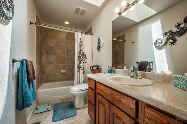 bathroom with a skylight, visible vents, toilet, vanity, and tile patterned floors