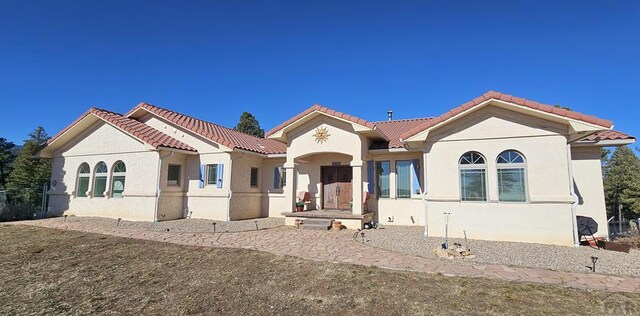 mediterranean / spanish house with a tile roof and stucco siding