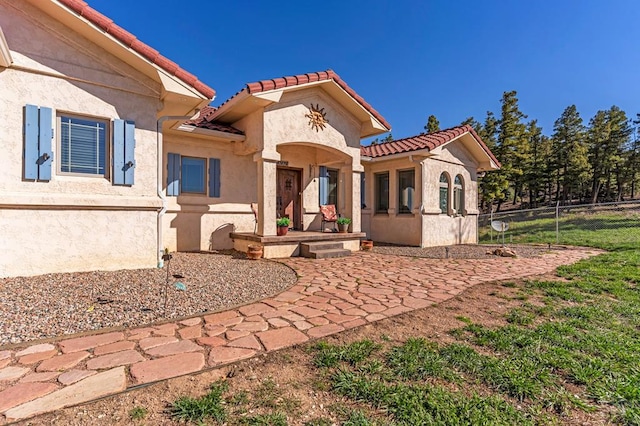 8760 Ridge Rd, Beulah, CO 81023 - view of front of home featuring fence, a tiled roof, and stucco siding