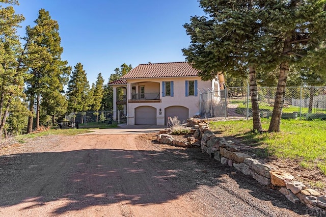 8760 Ridge Rd, Beulah, CO 81023 - mediterranean / spanish home with a tiled roof, fence, a balcony, concrete driveway, and an attached garage