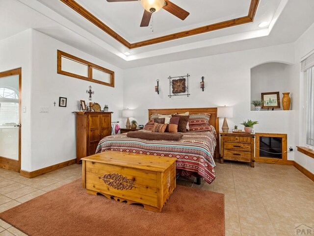 8760 Ridge Rd, Beulah, CO 81023 - bedroom featuring ceiling fan, crown molding, light tile patterned floors, baseboards, and a tray ceiling