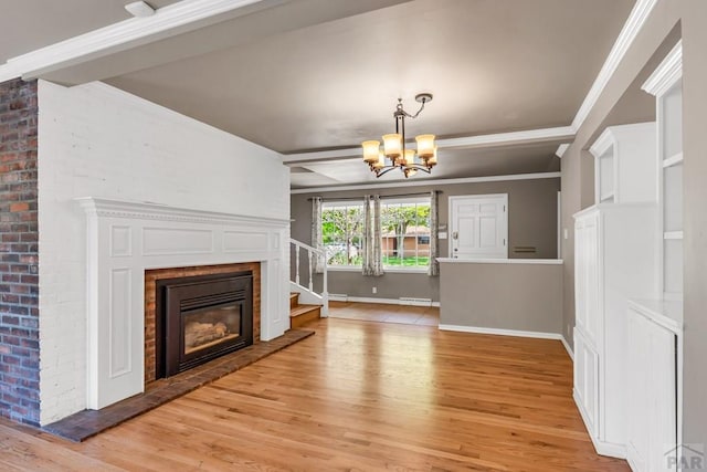 216 Dunsmere Ave, Pueblo, CO 81004 - unfurnished living room with light wood-style flooring, a chandelier, a brick fireplace, crown molding, and baseboards
