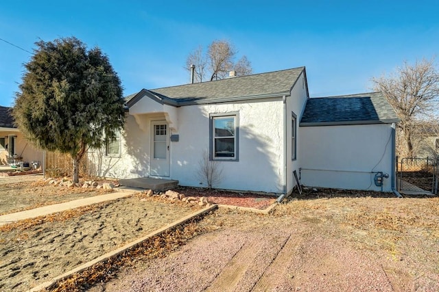 view of front of house featuring a shingled roof and stucco siding