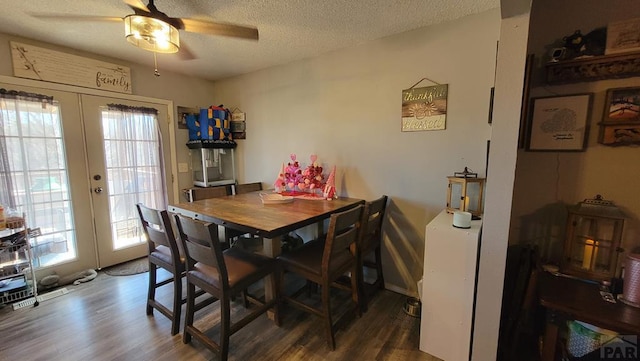 dining space featuring dark wood-style floors, french doors, a textured ceiling, and a ceiling fan