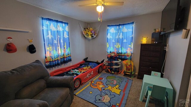 rec room featuring a textured ceiling, ceiling fan, and carpet floors