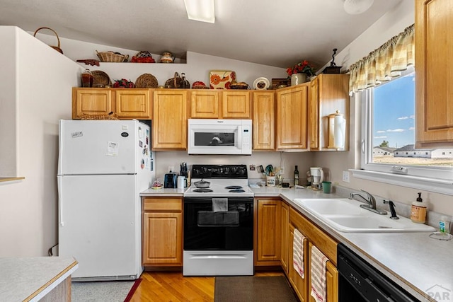 644 E Hahns Peak Ave, Pueblo West, CO 81007 - kitchen with white appliances, a sink, light countertops, vaulted ceiling, and light wood finished floors