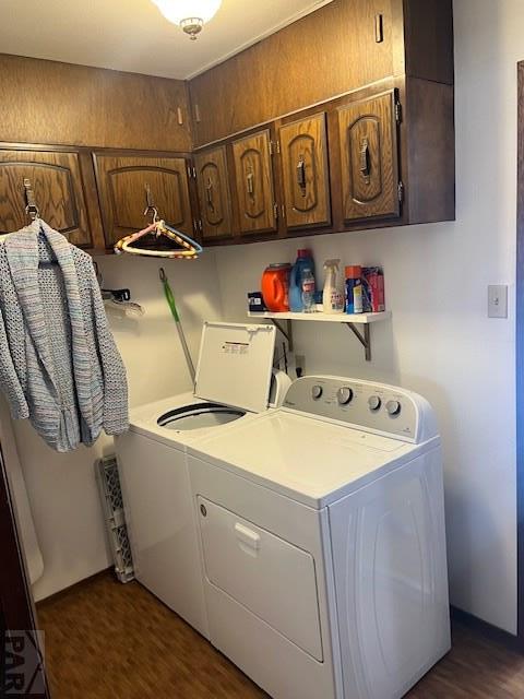 laundry room with dark wood-type flooring, washer and dryer, and cabinet space