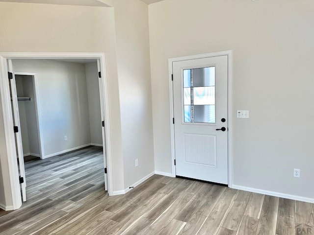 entryway featuring baseboards and wood finished floors