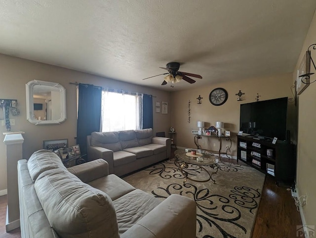 living area with a ceiling fan, a textured ceiling, and baseboards