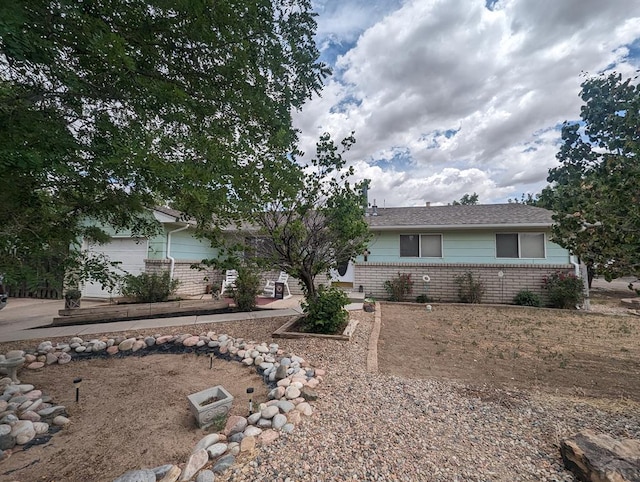 single story home with a garage, concrete driveway, and brick siding