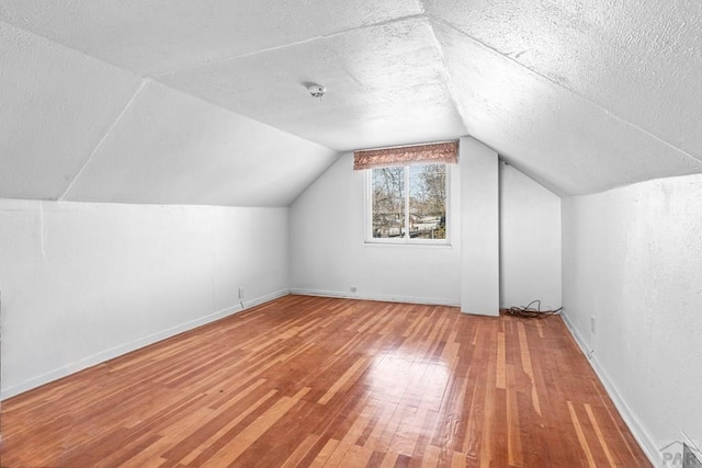 2701 Franklin Ave, Pueblo, CO 81003 - additional living space featuring baseboards, a textured ceiling, vaulted ceiling, and hardwood / wood-style floors