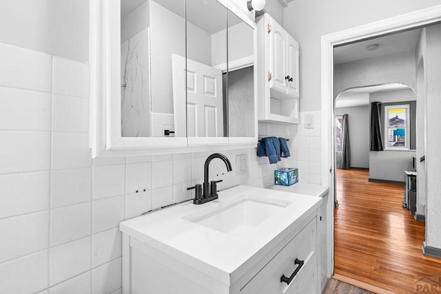 2701 Franklin Ave, Pueblo, CO 81003 - bathroom with vanity, tasteful backsplash, wood finished floors, and tile walls