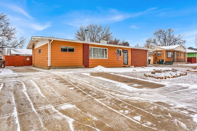 ranch-style home featuring fence