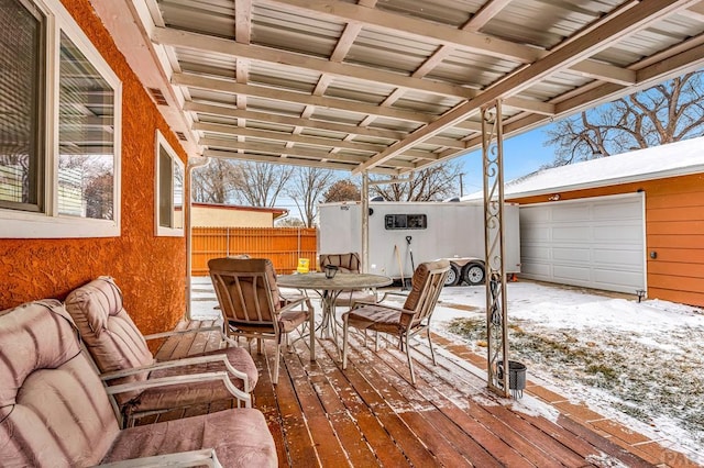 snow covered deck with fence and outdoor dining area