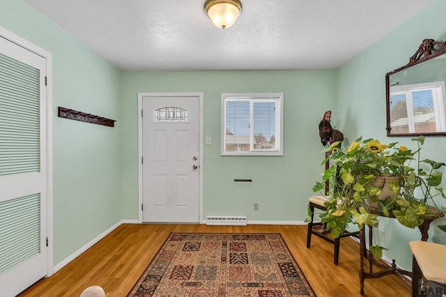 entryway featuring a healthy amount of sunlight, visible vents, baseboards, and wood finished floors