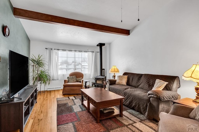 living area featuring a wood stove, a baseboard heating unit, beamed ceiling, and wood finished floors