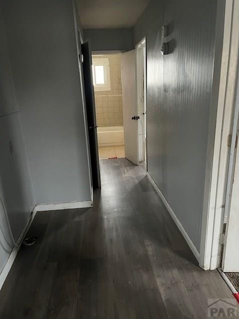 hallway featuring dark wood-style floors and baseboards