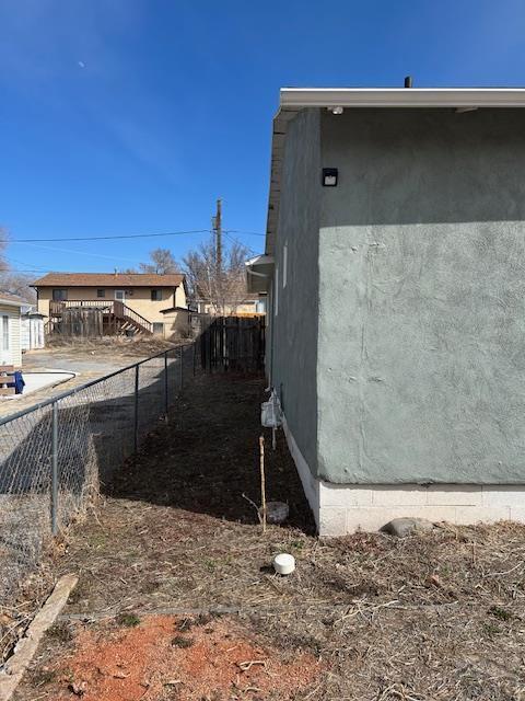 view of property exterior with fence and stucco siding