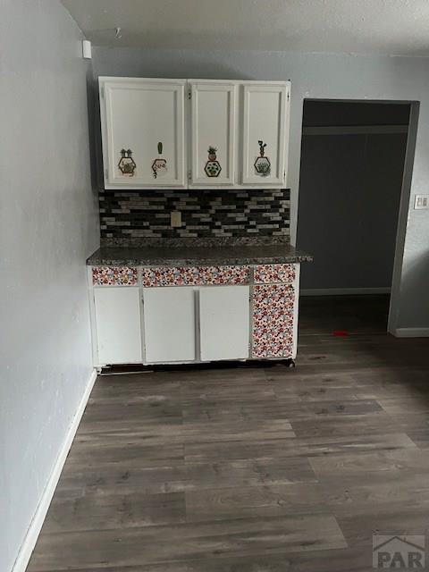 interior details with decorative backsplash, wood finished floors, and baseboards