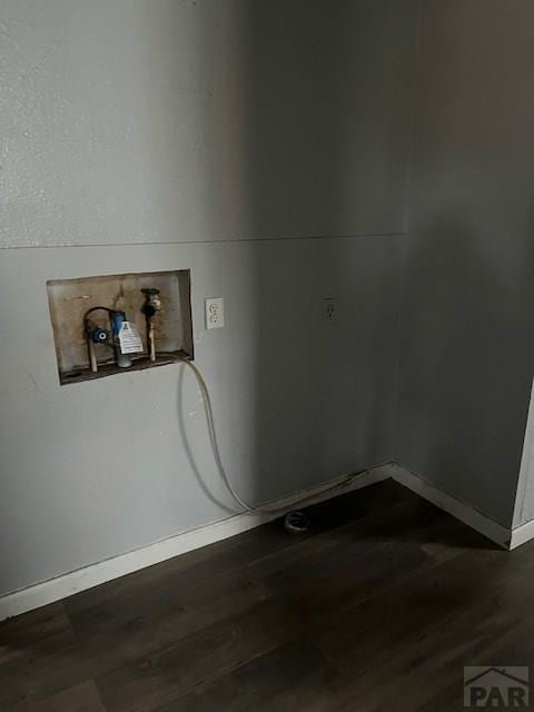 clothes washing area featuring dark wood finished floors and baseboards