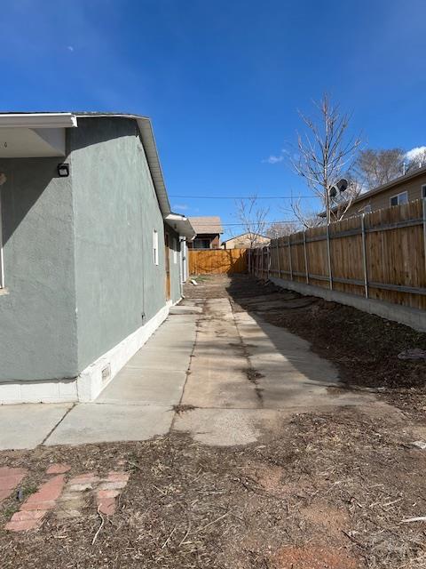 view of side of property with stucco siding and a fenced backyard