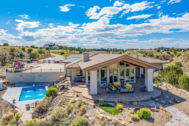 rear view of property featuring a fenced in pool, a chimney, a tiled roof, fence, and a patio area