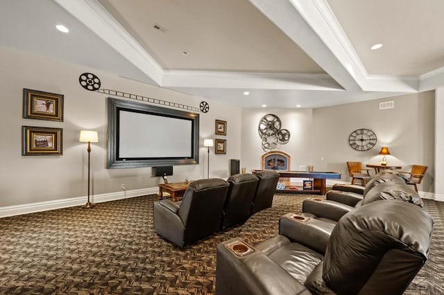 home theater featuring a fireplace, baseboards, dark colored carpet, a raised ceiling, and crown molding