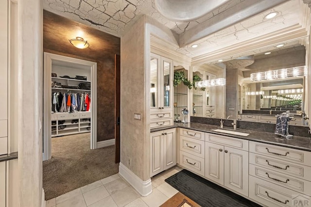 full bathroom featuring a spacious closet, tile patterned flooring, vanity, and baseboards