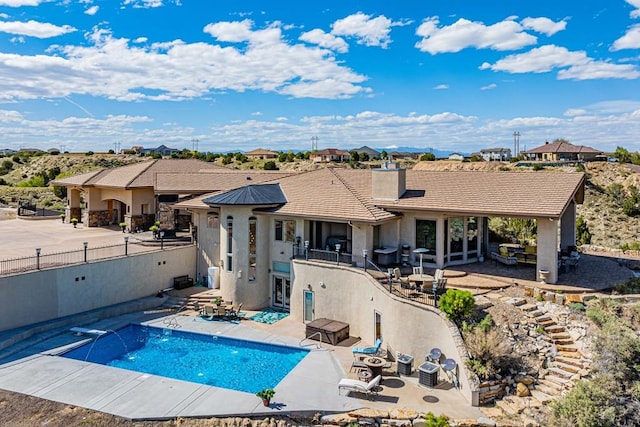 back of house featuring a patio, fence, a tiled roof, a fenced in pool, and stucco siding