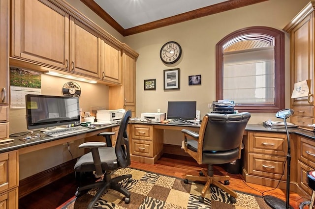 office area with light wood finished floors, ornamental molding, and built in study area