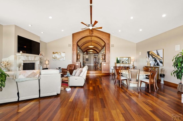 living area featuring dark wood-style floors, a premium fireplace, vaulted ceiling, and recessed lighting