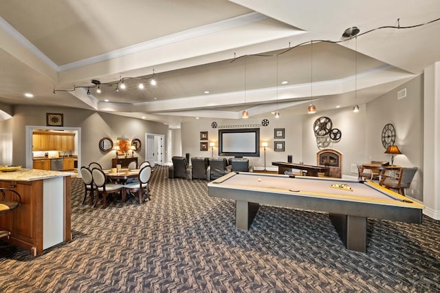 playroom with ornamental molding, dark colored carpet, and a tray ceiling