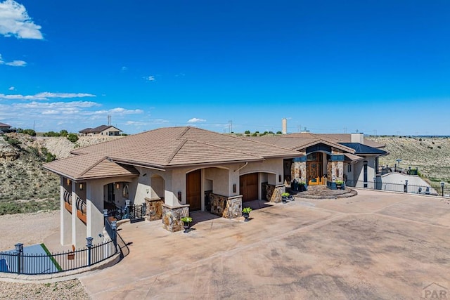 view of front of house featuring fence, concrete driveway, and stucco siding