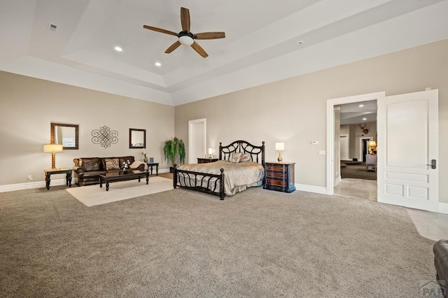 bedroom featuring carpet floors, a tray ceiling, recessed lighting, and baseboards