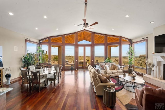 living room with a fireplace with raised hearth, ceiling fan, lofted ceiling, recessed lighting, and dark wood-style flooring