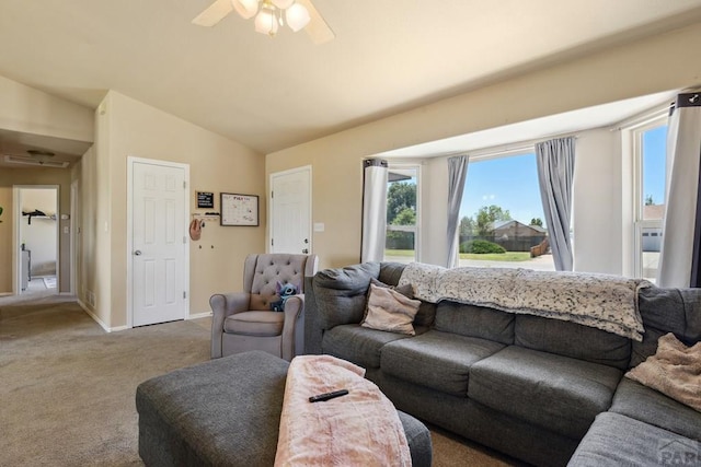 carpeted living room featuring a ceiling fan, vaulted ceiling, and baseboards