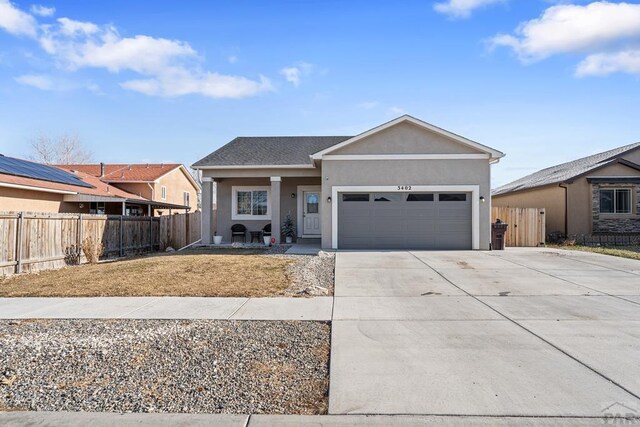 ranch-style home with fence, driveway, an attached garage, and stucco siding