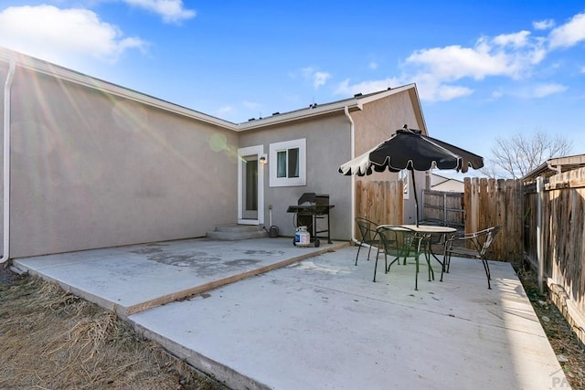 back of property with outdoor dining area, a patio area, a fenced backyard, and stucco siding