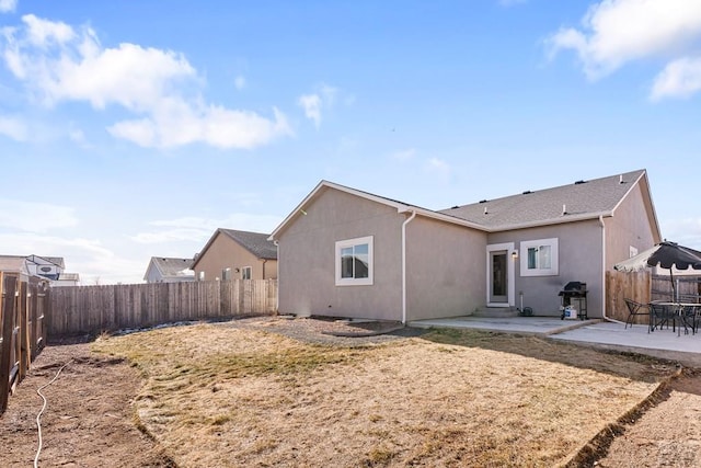 back of house featuring a patio, a fenced backyard, and stucco siding