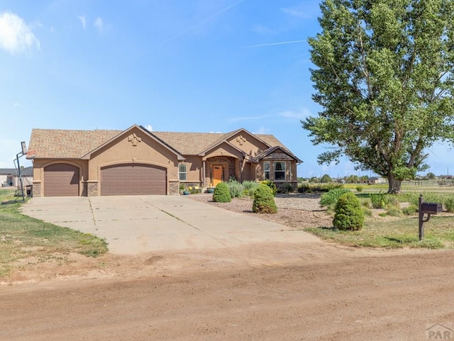 406 N Idledale Dr, Pueblo West, CO 81007 - view of front of house with a garage, stucco siding, concrete driveway, and stone siding