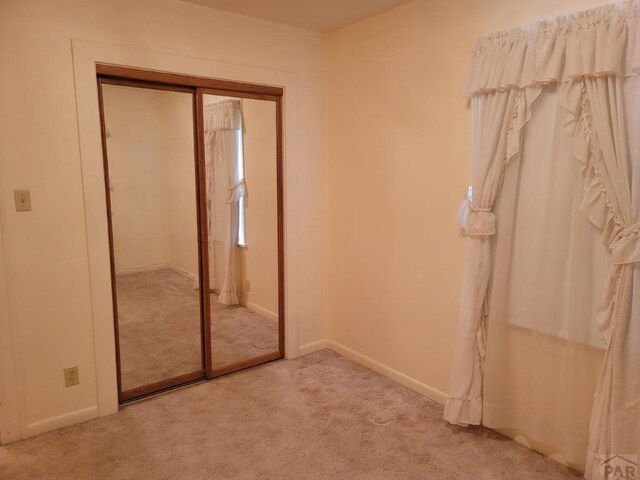 unfurnished bedroom with a closet and carpet flooring