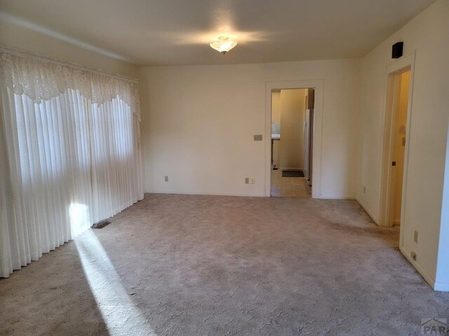 unfurnished room with light colored carpet