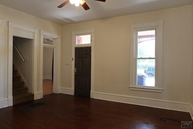 foyer entrance with dark wood-style flooring, visible vents, stairway, ceiling fan, and baseboards