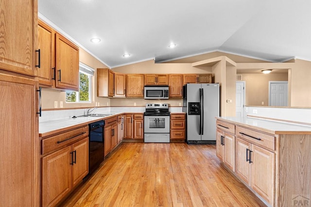 503 N Iliff Dr, Pueblo West, CO 81007 - kitchen featuring stainless steel appliances, vaulted ceiling, a sink, crown molding, and light wood finished floors
