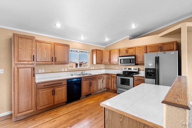 503 N Iliff Dr, Pueblo West, CO 81007 - kitchen with stainless steel appliances, ornamental molding, a sink, tile countertops, and light wood-style flooring