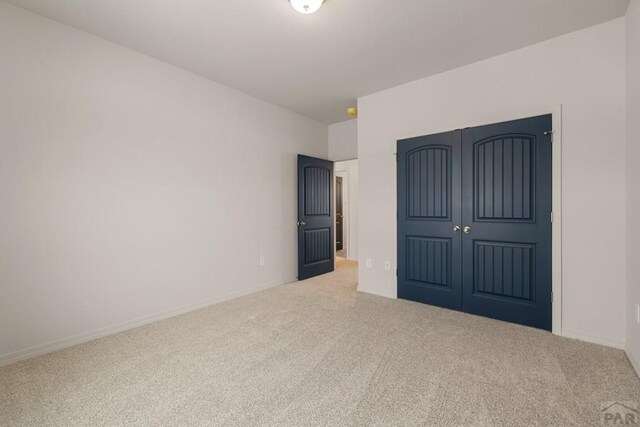 unfurnished bedroom featuring a closet, carpet, and baseboards