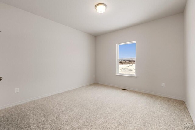 unfurnished room featuring carpet floors, baseboards, and visible vents