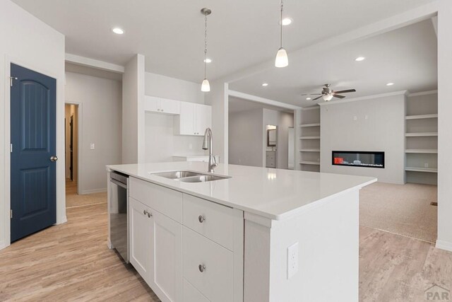 kitchen featuring white cabinetry, a sink, and an island with sink