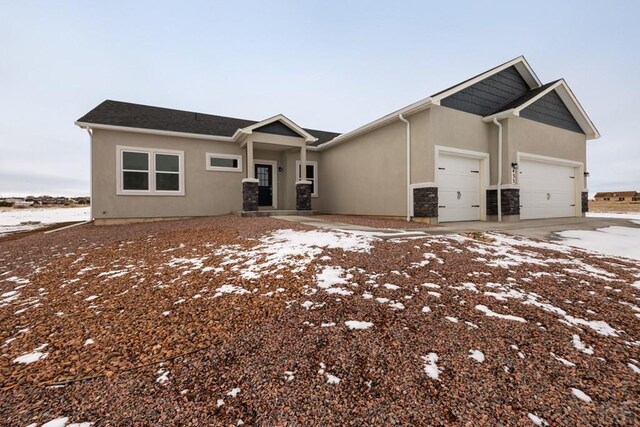 view of front of home with concrete driveway, stone siding, an attached garage, and stucco siding