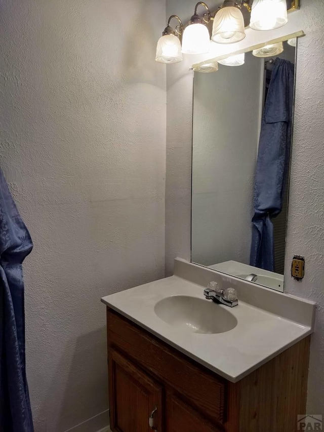 bathroom featuring a textured wall and vanity